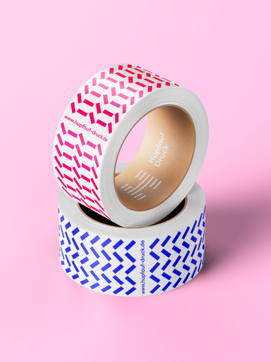 Zwei Rollen Klebeband mit Hupfauf-Druck-Muster in Pink und Blau auf rosa Hintergrund