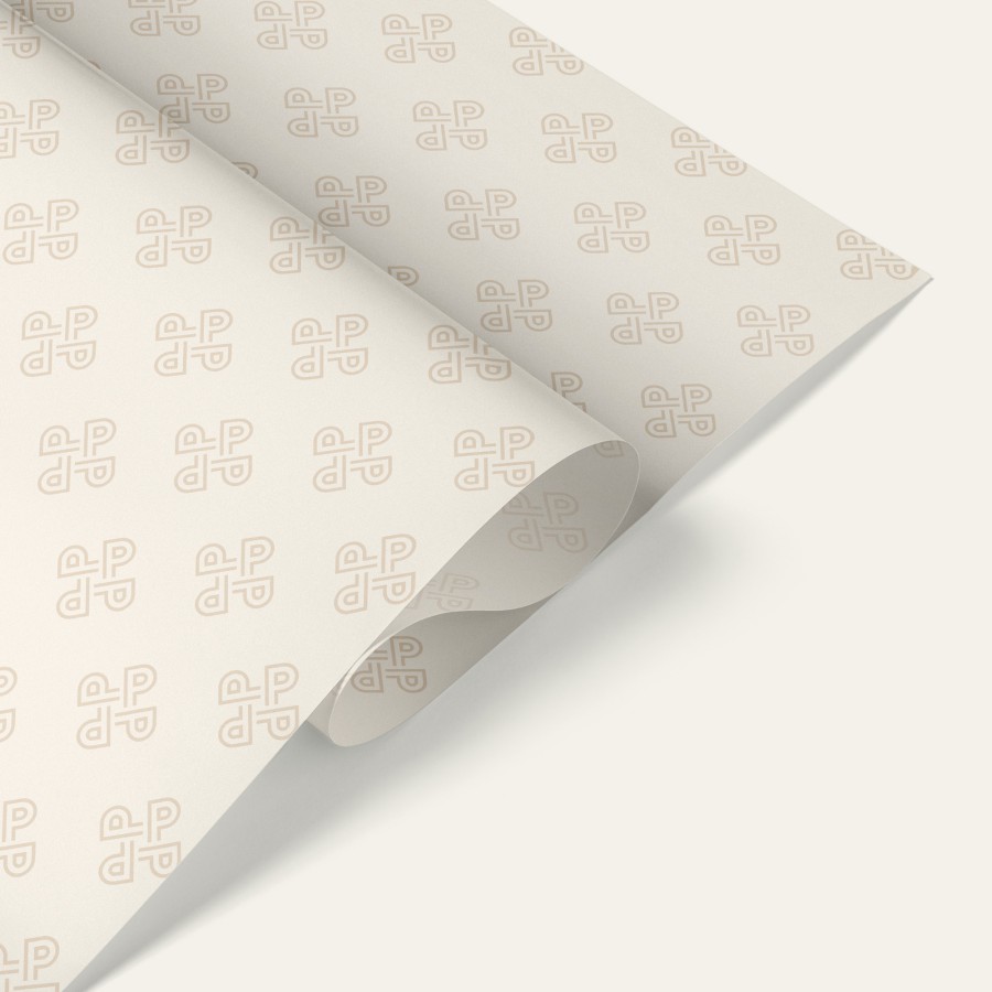 White packing paper with an all-over pattern featuring the Pure Pastry logo in light gray, loosely folded